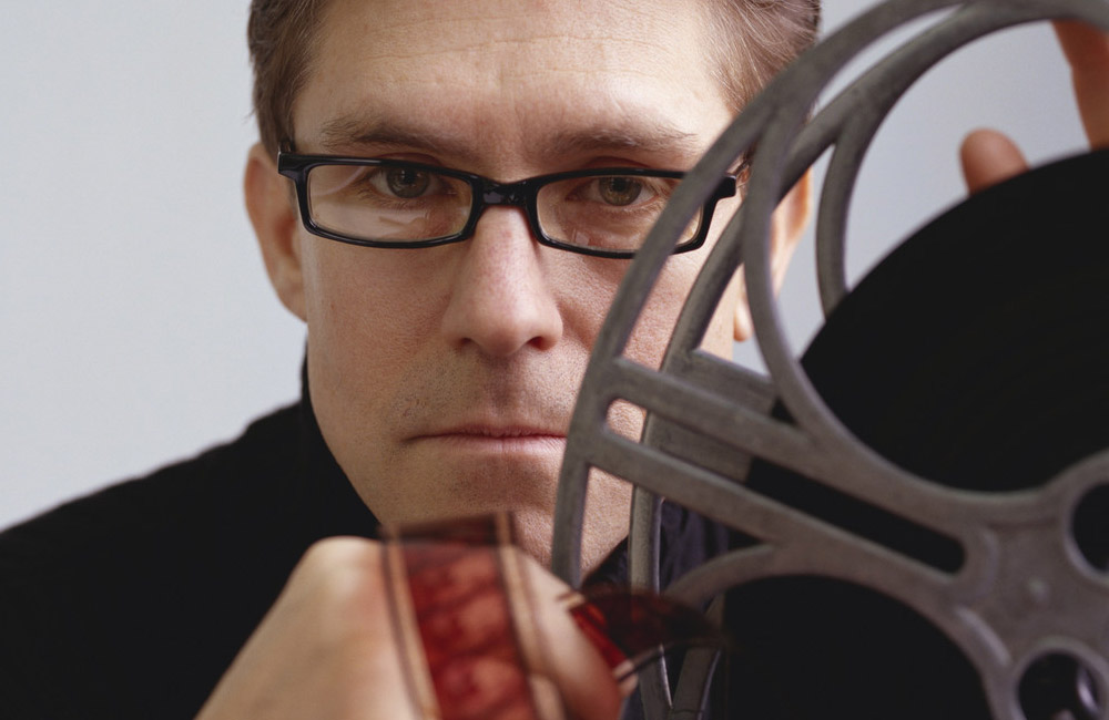 A man holds a movie projector film reel