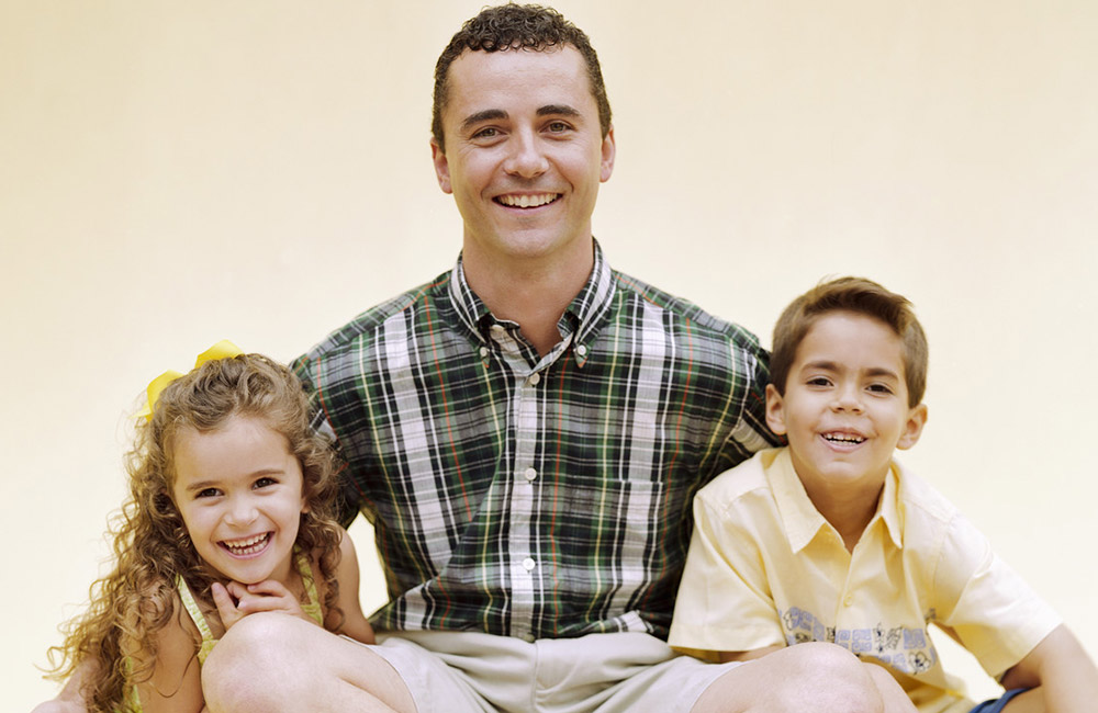 A parent sits with his two young children