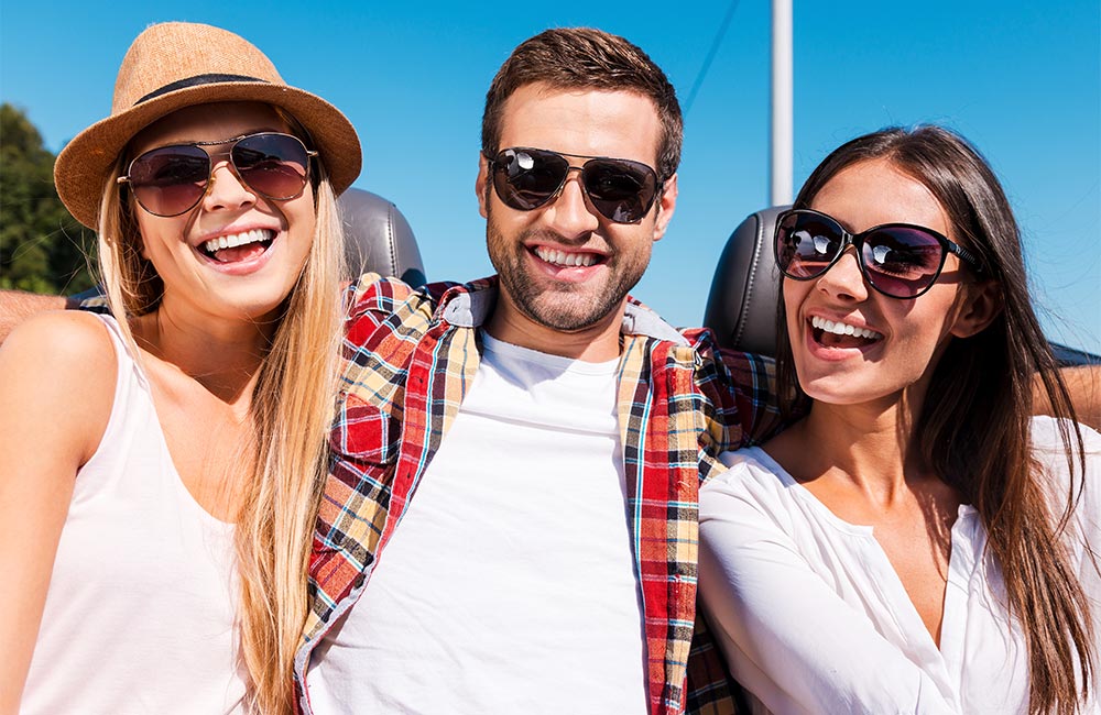 Three young adults smile happily